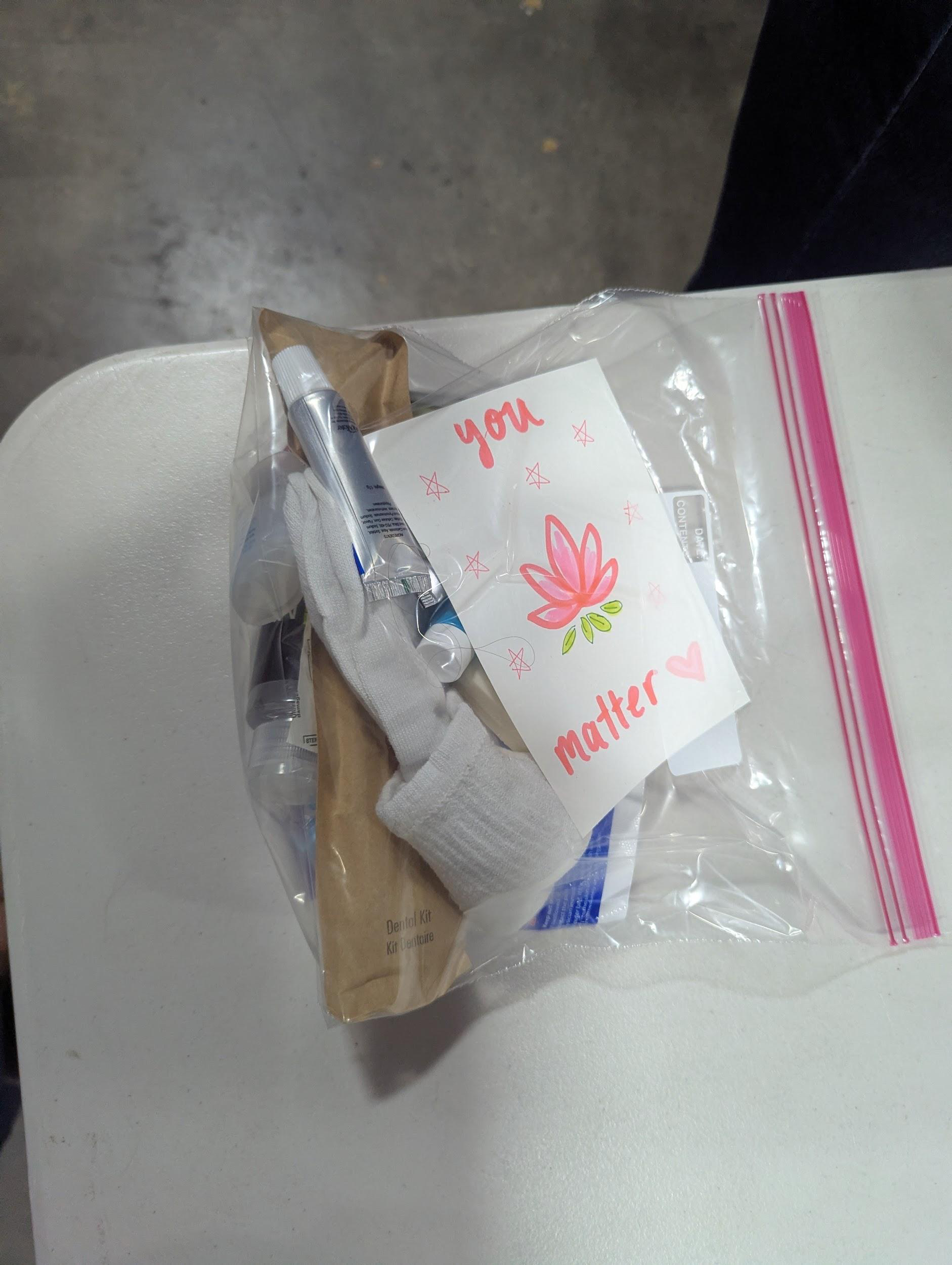 A sealed summer hygiene kit with socks, dental kit, toiletries and a handwritten You Matter card